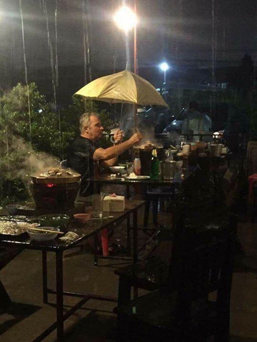 ฝรั่งนั่งชิลกินหมูกระทะท่ามกลางสายฝนโปรยปราย