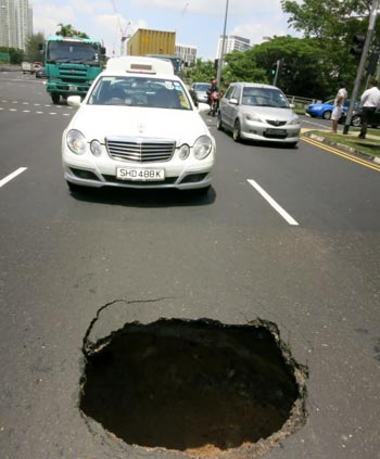 หลุมยุบกลางถนนสิงคโปร์ลึก 3 เมตร มอเตอร์ไซค์หวิดดับ