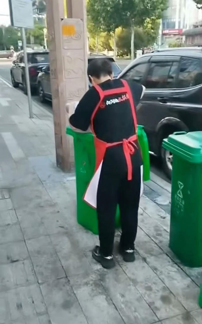 พนักงานร้านอาหาร ตักน้ำมันใช้แล้วจากถังขยะ