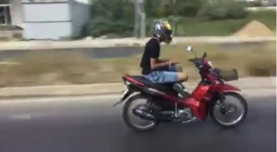 นั่งขัดสมาธิ เล่นมือถือ ขณะขี่มอเตอร์ไซค์