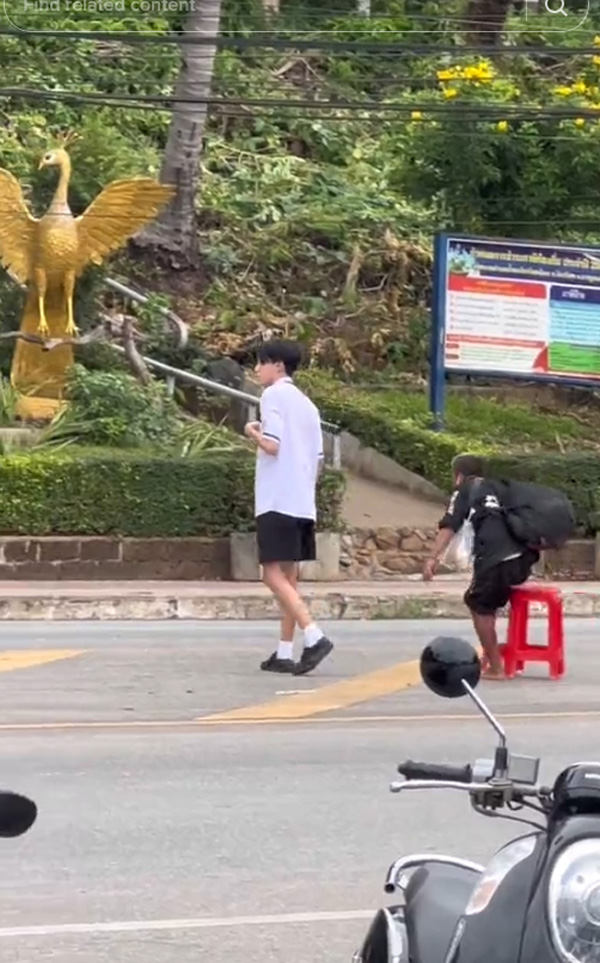 นักเรียนชายพายายข้ามถนน