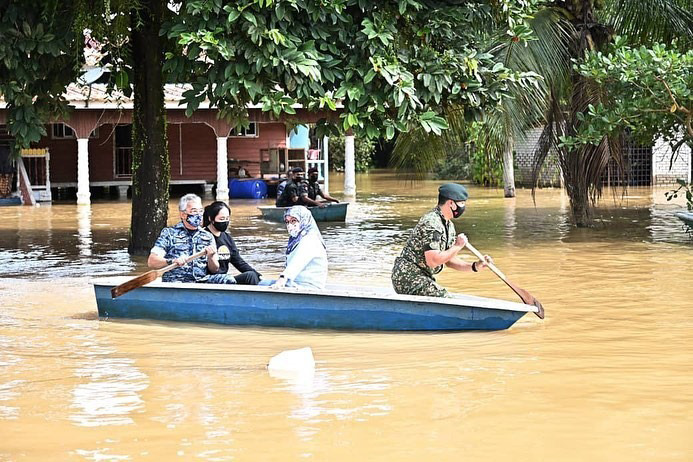 กษัตริย์มาเลเซีย พายเรือลุยน้ำท่วม ช่วยชาวบ้าน