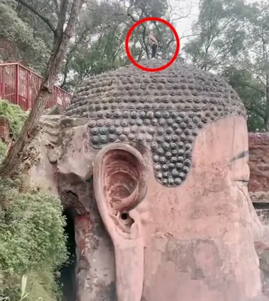 นักท่องเที่ยวยืนฉี่บนเศียรพระ 