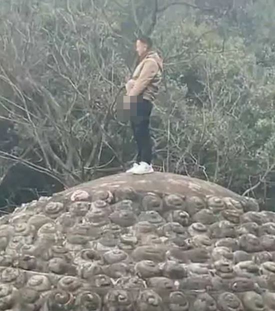 นักท่องเที่ยวยืนฉี่บนเศียรพระ 