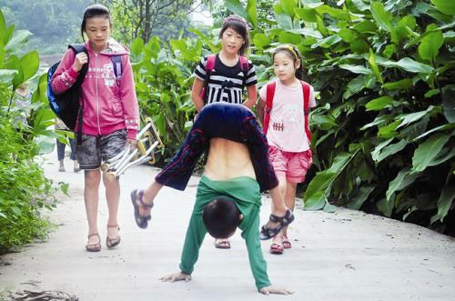 เด็กชายจีนอัมพาตขา ให้มือเดินต่างเท้าไปโรงเรียนทุกวัน 