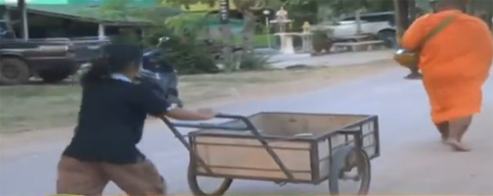 เด็กวัดหญิงเดินถือปิ่นโตตามพระภิกษุสงฆ์บิณฑบาต